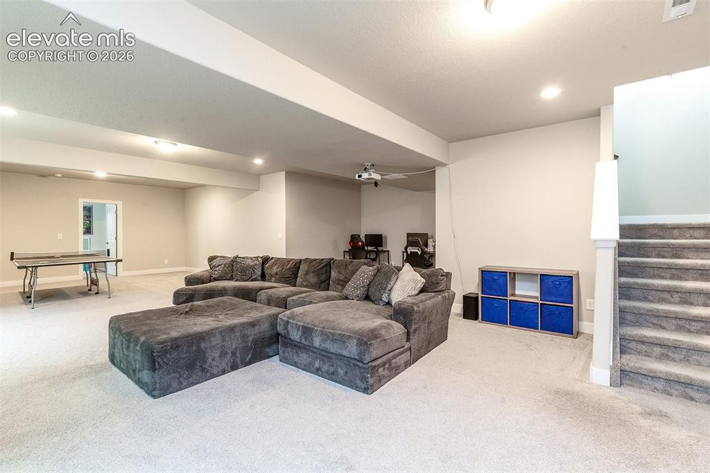 Image 25 of 43: Spacious carpeted room featuring recessed lighting and a built-in staircase