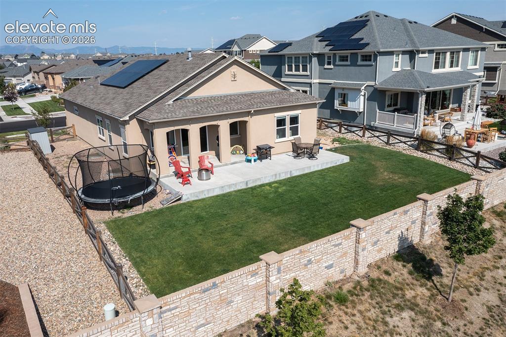 Image 34 of 43: Stucco exterior with a concrete patio, a private yard with a stone-accented