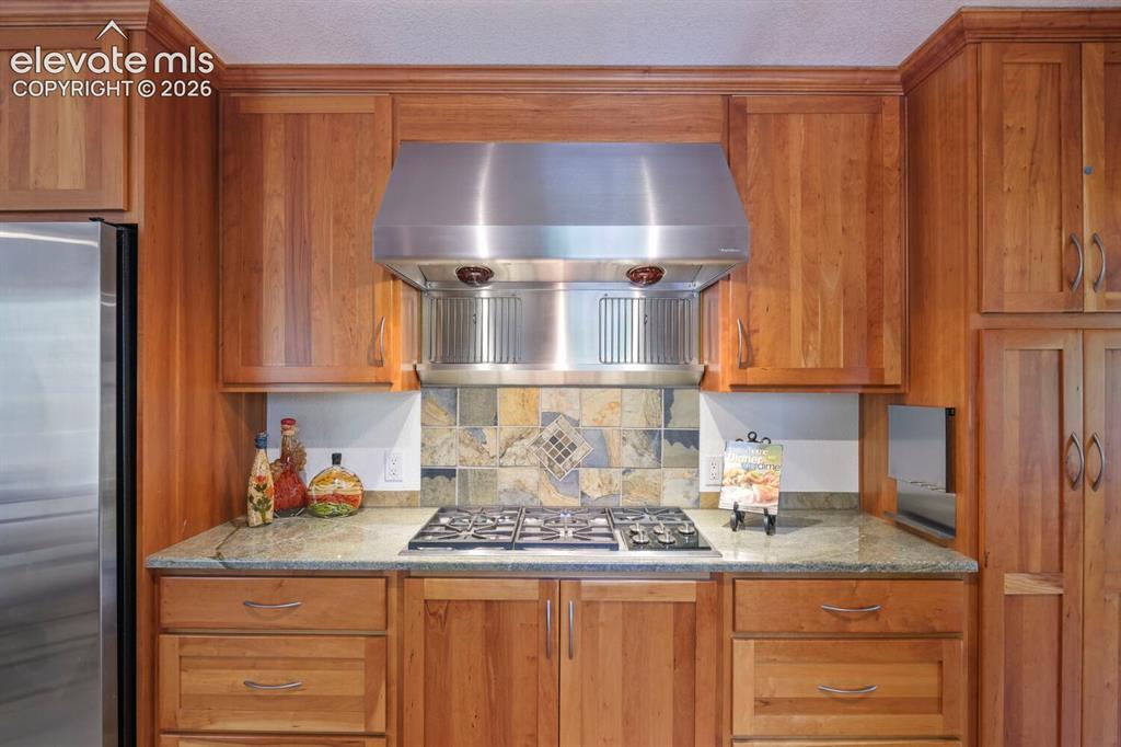 Image 13 of 50: Kitchen featuring wood-finish cabinetry, stainless steel appliances includi