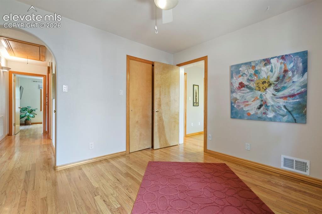 Image 18 of 50: Room featuring wood-finish flooring, a ceiling fan with integrated lighting