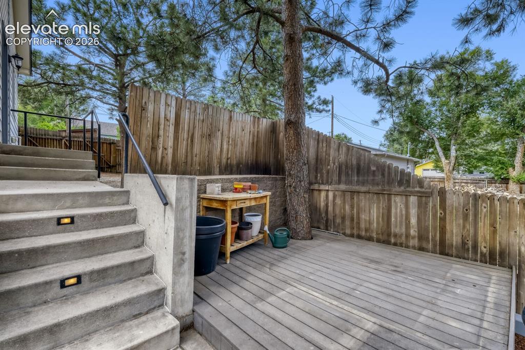 Image 24 of 50: Expansive outdoor deck featuring wood-finish flooring, mature trees, and pr