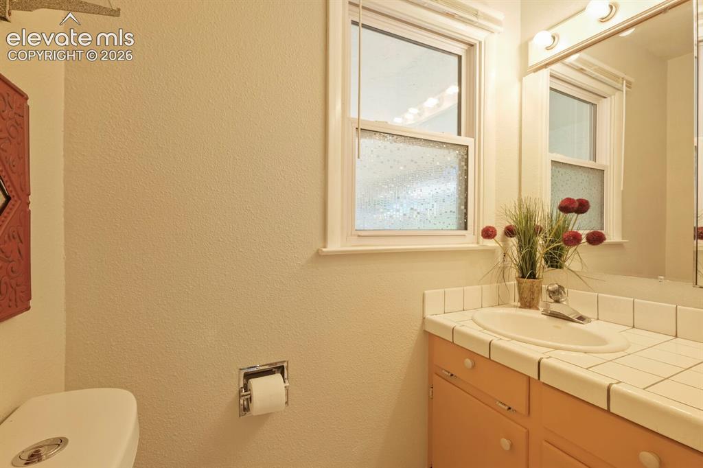 Image 26 of 50: Bathroom featuring a corner toilet, a single window, and a shower enclosure