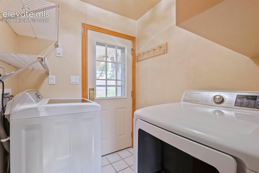 Image 27 of 50: Bathroom vanity featuring an integrated sink, tile countertop, and wood-fin