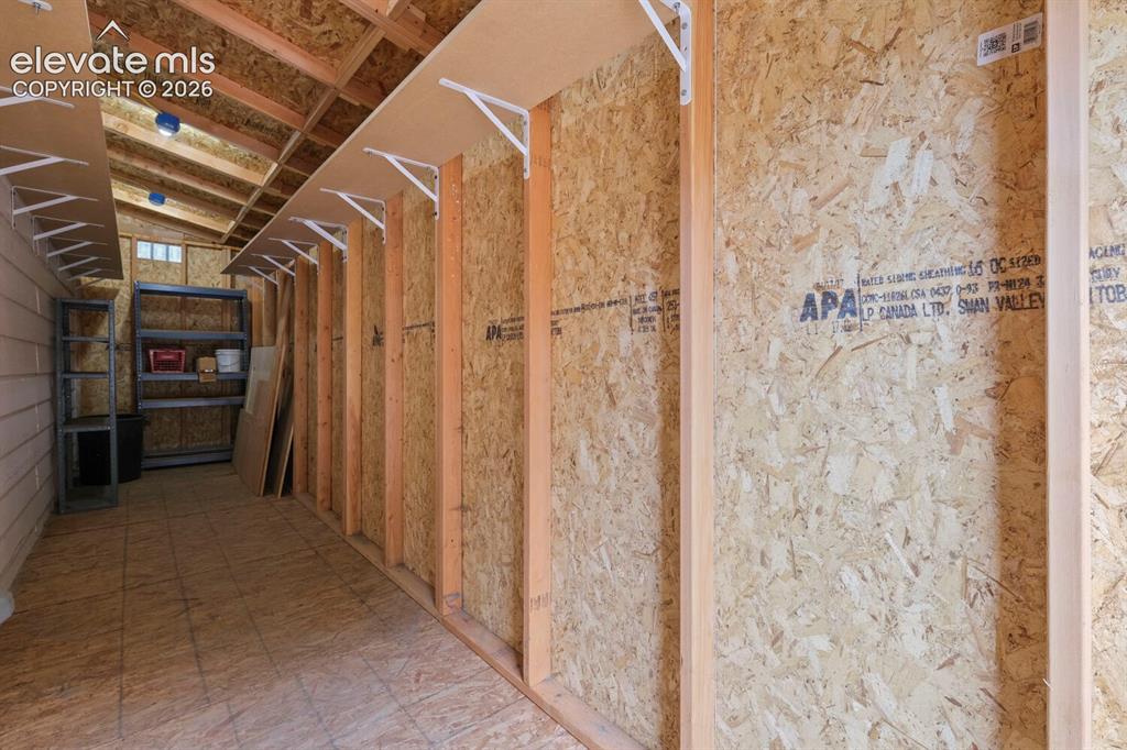 Image 28 of 50: Dedicated laundry area featuring white tile flooring, a paneled door with w