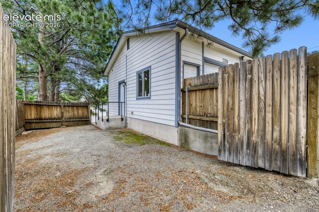 Image 34 of 50: Tiered backyard featuring a manicured lawn, concrete patio, and a staircase