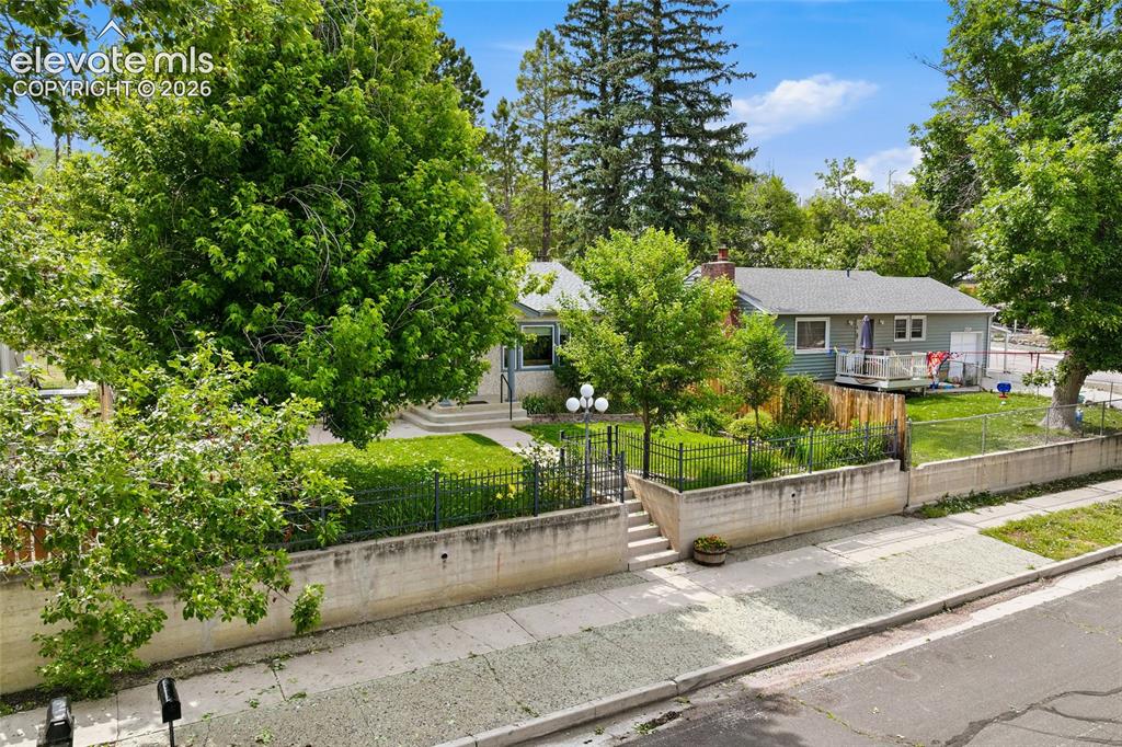 Image 38 of 50: Charming bungalow featuring a light-colored stucco exterior and a gray shin