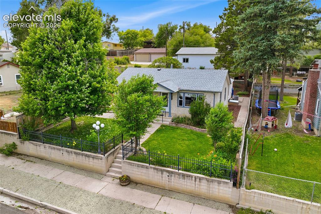 Image 39 of 50: Front exterior featuring a terraced landscape with retaining walls and a bl