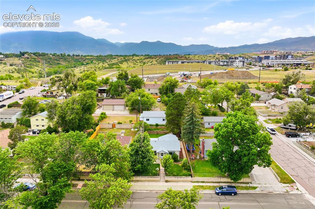 Image 42 of 50: Residential neighborhood featuring mature trees and mountain scenery