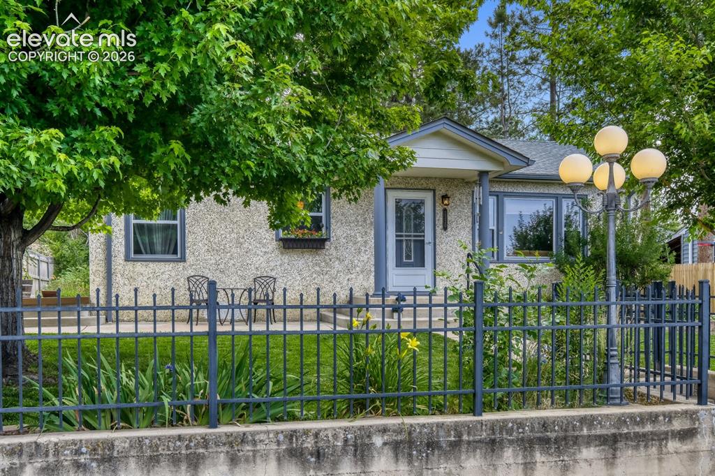 Image 5 of 50: Stucco exterior featuring a covered porch entry with columns
