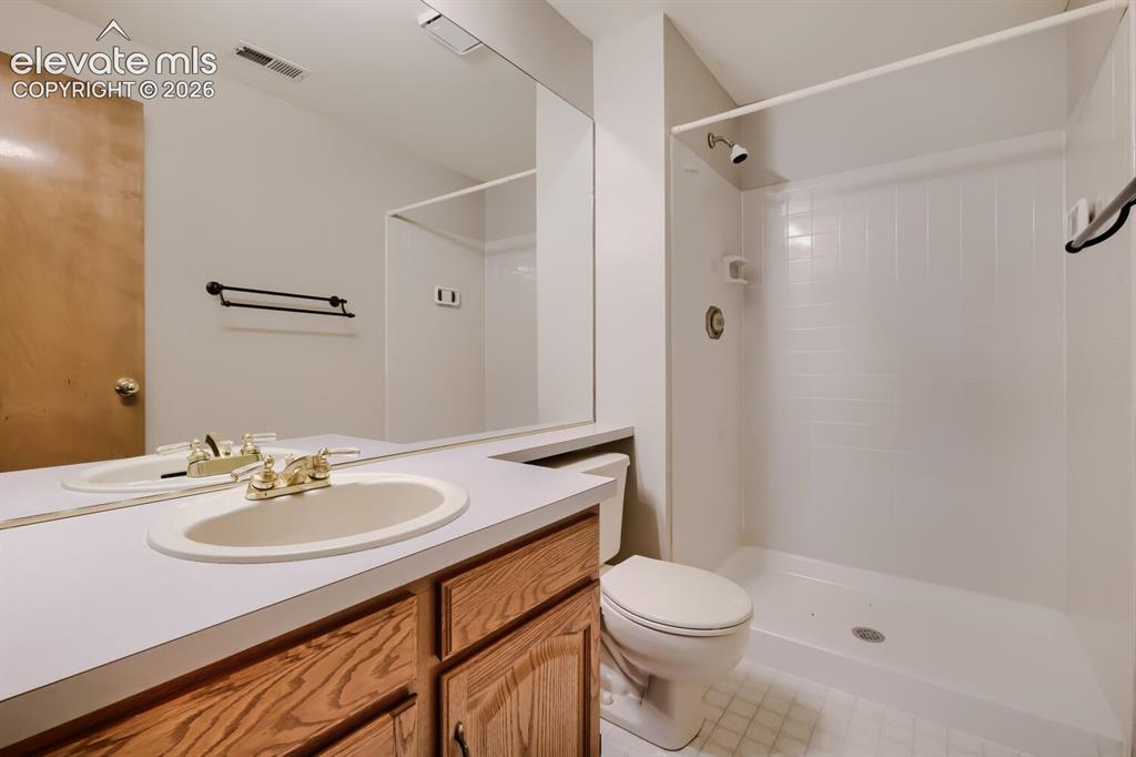 Image 14 of 28: Bathroom featuring an integrated countertop sink with brass-finish faucet, 