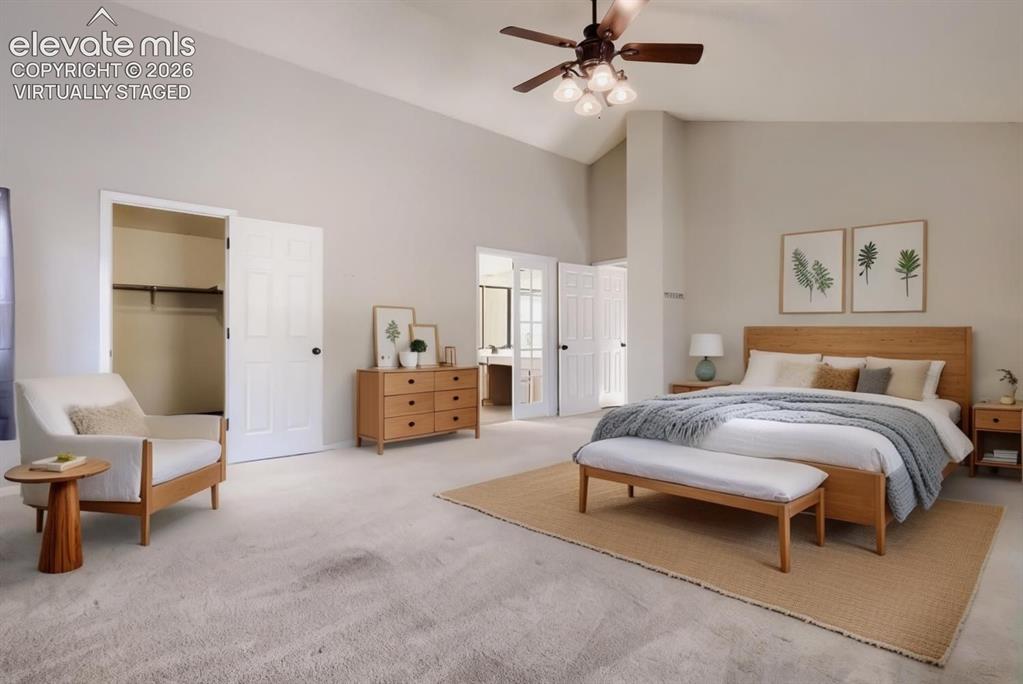 Image 15 of 28: Spacious bedroom featuring vaulted ceilings, plush carpeting, a ceiling fan