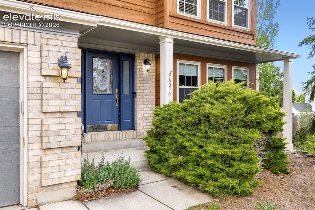 Image 3 of 28: Brick and wood-sided exterior featuring a covered entry