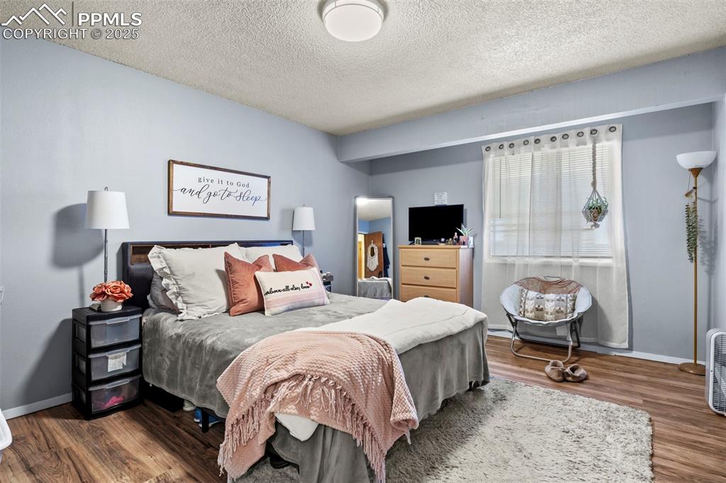 Image 17 of 31: Bedroom with a textured ceiling and wood finished floors