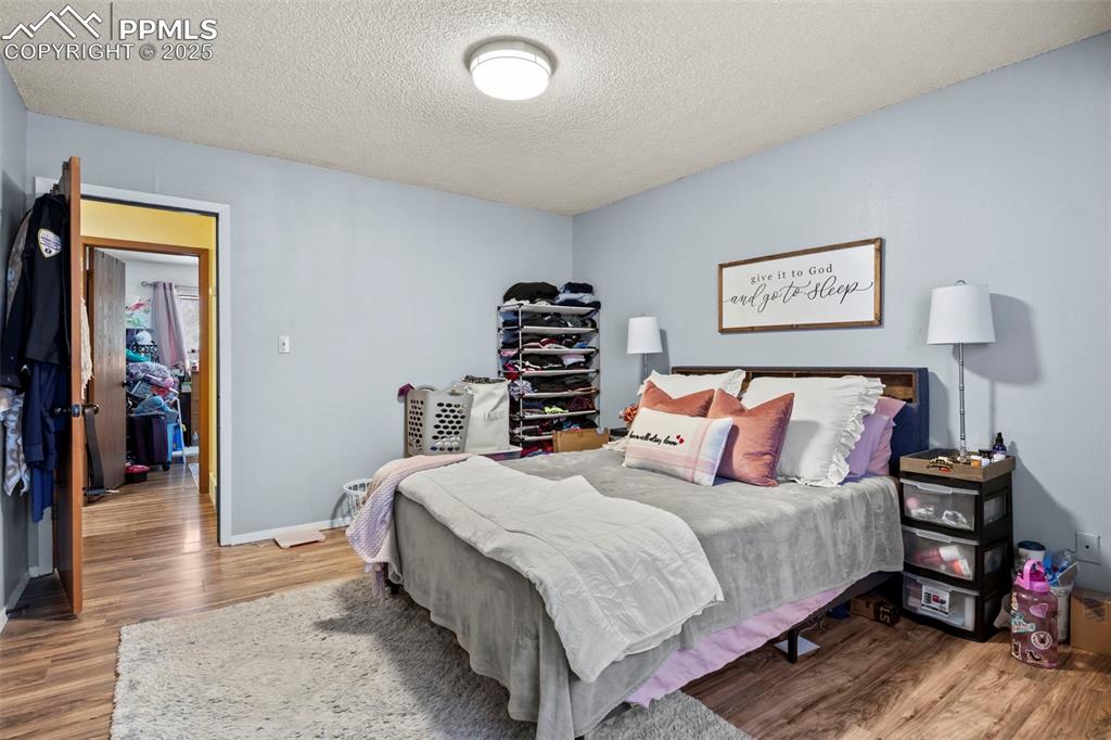 Image 19 of 31: Bedroom featuring a textured ceiling and wood finished floors