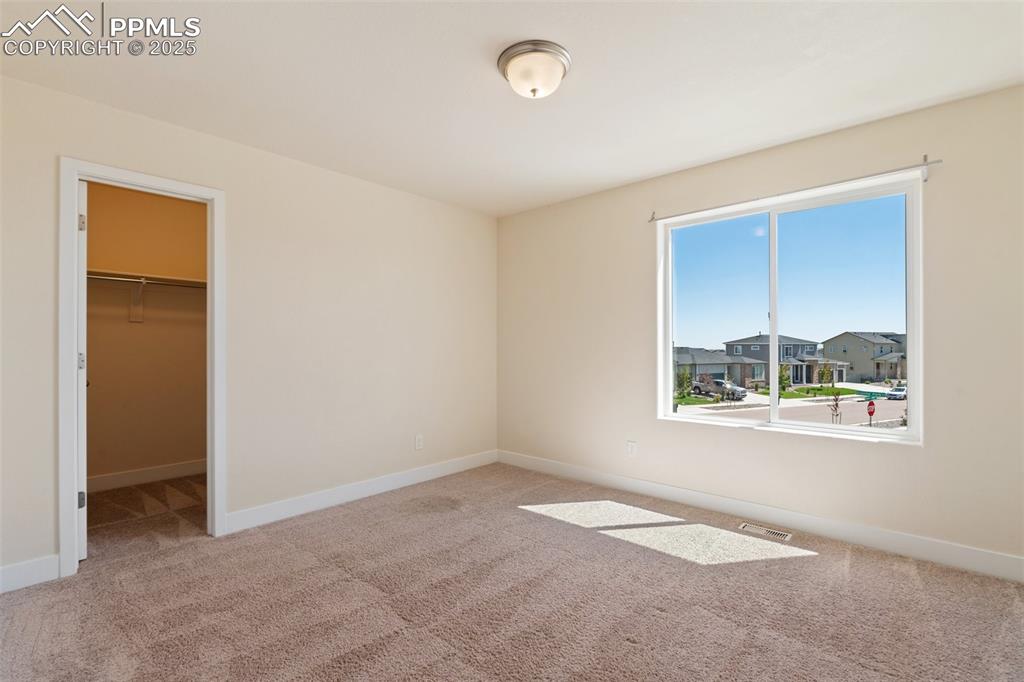 Image 13 of 35: Unfurnished bedroom featuring carpet floors, a walk in closet, and a closet