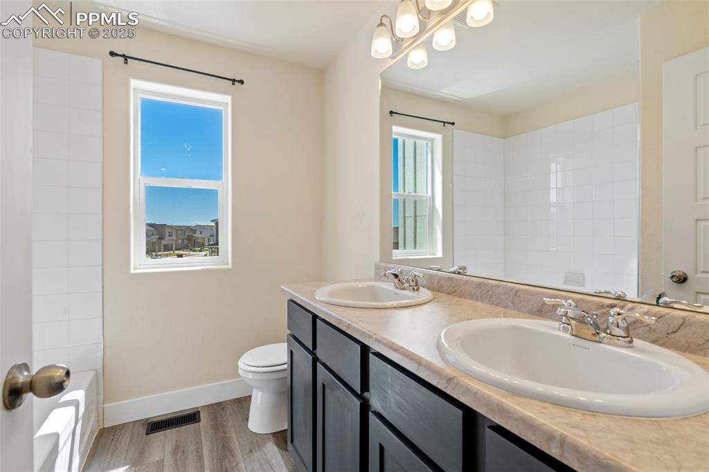Image 15 of 35: Bathroom featuring double vanity and wood finished floors