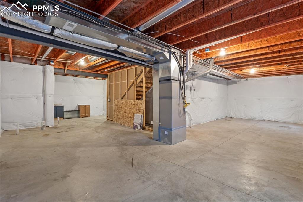 Image 24 of 35: Unfinished basement featuring stairs and heating unit