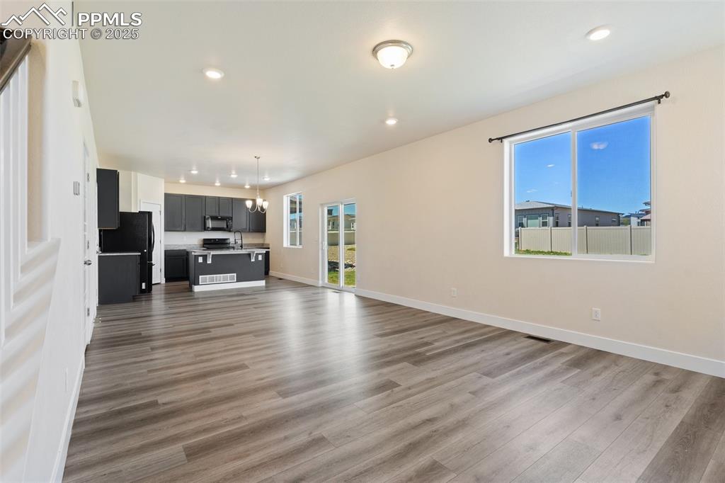 Image 5 of 35: Unfurnished living room featuring wood finished floors and recessed lightin