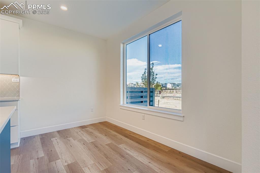 Image 11 of 28: Unfurnished dining area featuring light wood finished floors and recessed l
