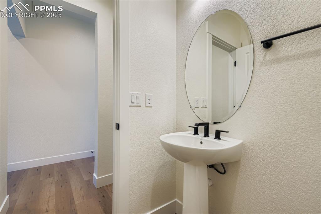 Image 12 of 28: Bathroom with a textured wall and wood-type flooring