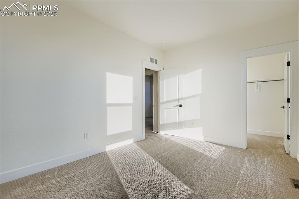 Image 18 of 28: Unfurnished bedroom with carpet floors and a spacious closet