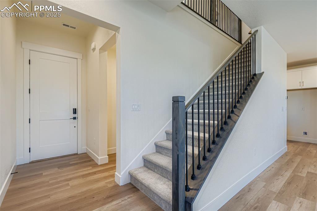 Image 4 of 28: Stairway featuring wood finished floors