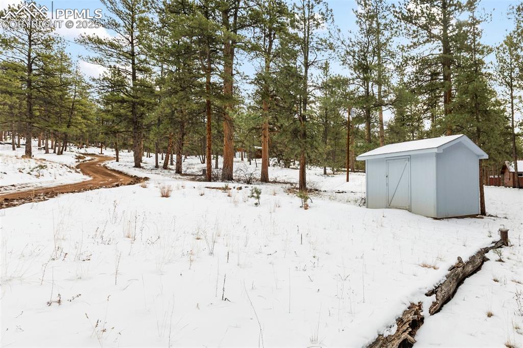 Image 35 of 46: Storage shed and well across the street, with extra parking area