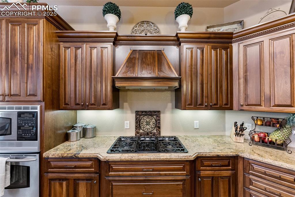 Image 11 of 50: Five burner gas cooktop and under cabinet lighting