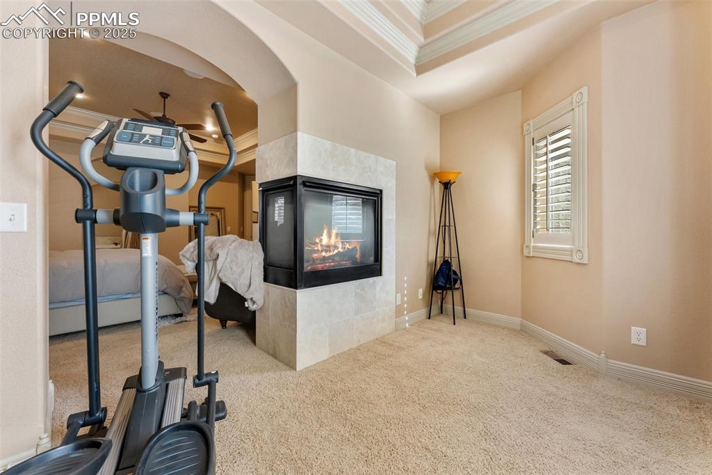 Image 19 of 50: Just off the primary bedroom is a sitting area and three sided gas fireplac