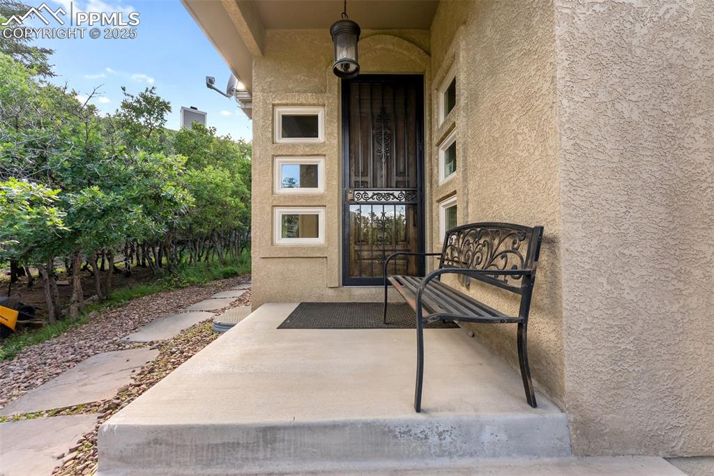 Image 2 of 50: Covered front entry with a steel storm door