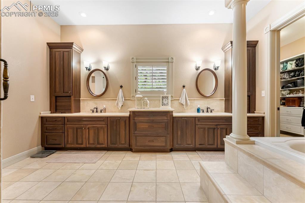 Image 21 of 50: Large primary bedroom with ceramic tile flooring and dual sinks