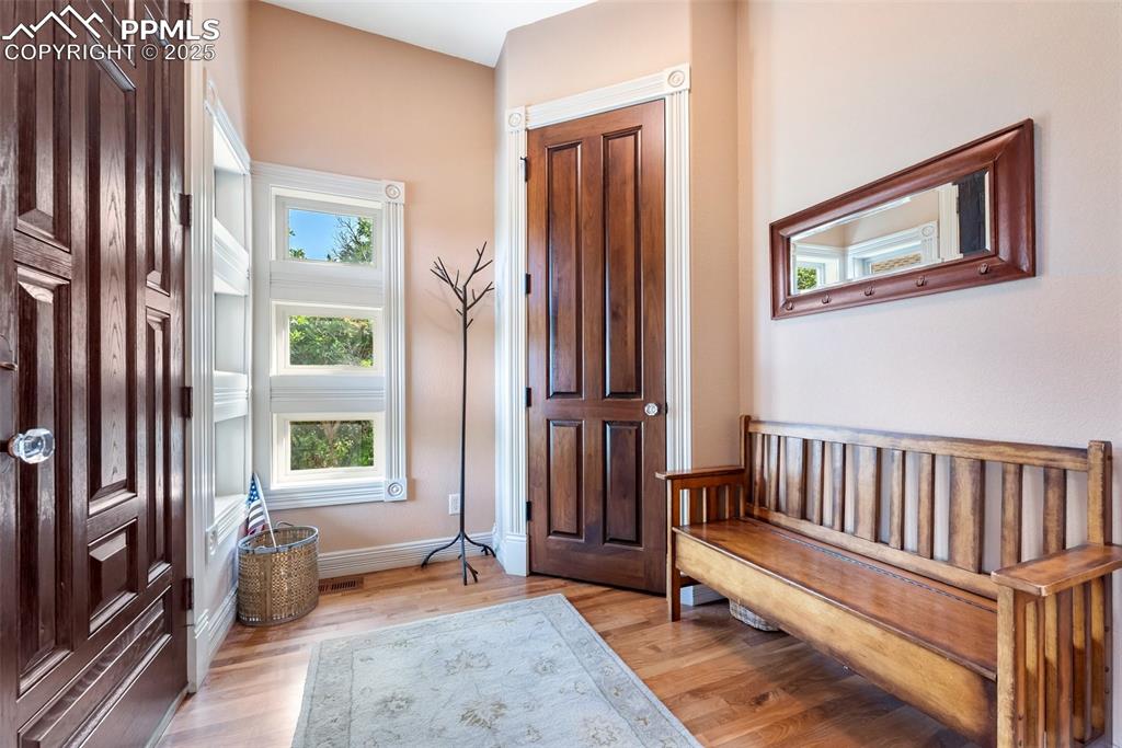 Image 3 of 50: Bright entry with natural wood flooring