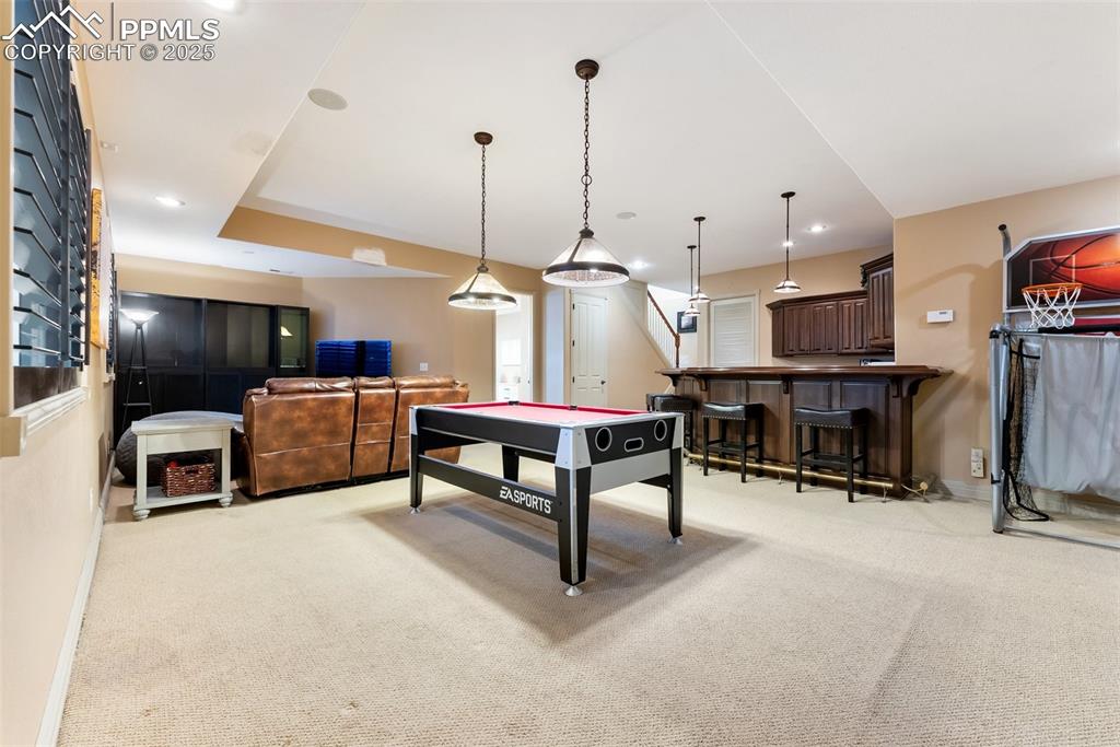 Image 32 of 50: Basement recreation room with a full wet bar