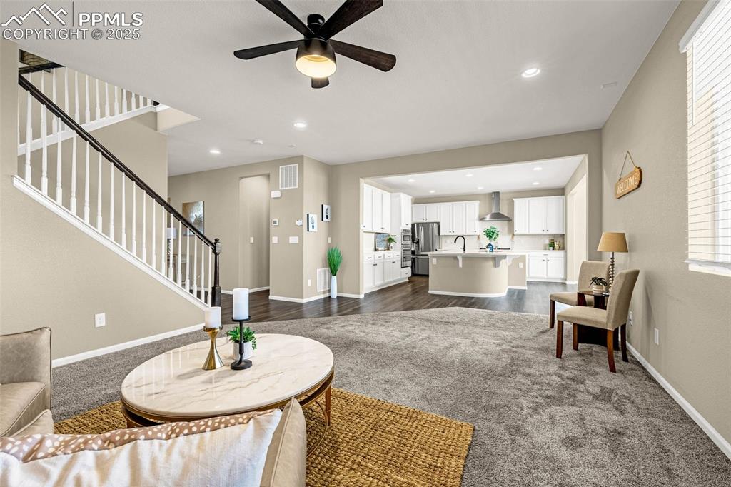Image 10 of 42: Living room with stairway, recessed lighting, ceiling fan, and dark carpet