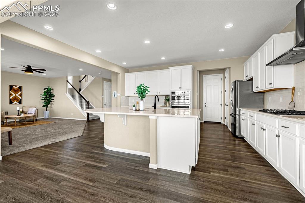 Image 13 of 42: Kitchen featuring decorative backsplash, white cabinetry, recessed lighting