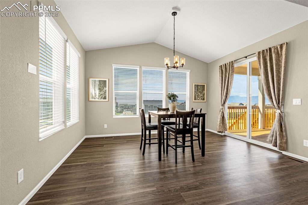 Image 16 of 42: Dining area with a chandelier, plenty of natural light, lofted ceiling, and