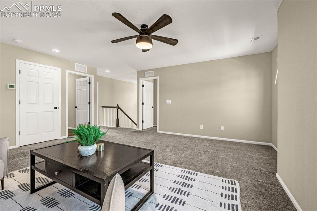 Image 22 of 42: Carpeted living room featuring ceiling fan and recessed lighting