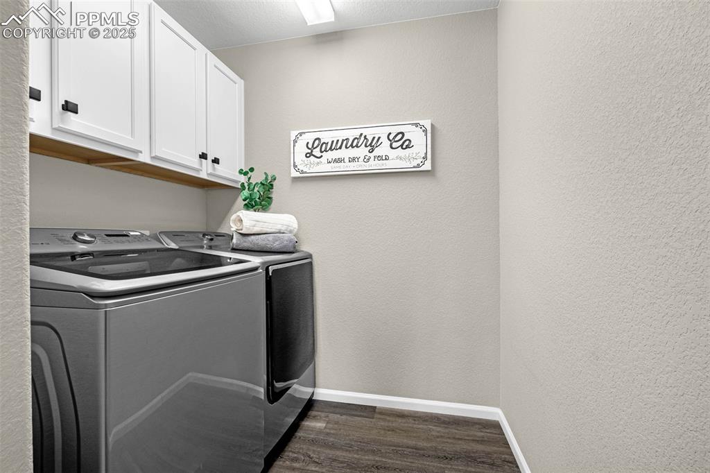 Image 23 of 42: Laundry room with a textured wall, dark wood-type flooring, washer and clot