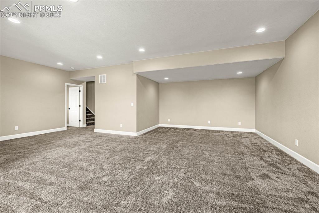 Image 29 of 42: Carpeted spare room with recessed lighting and stairs