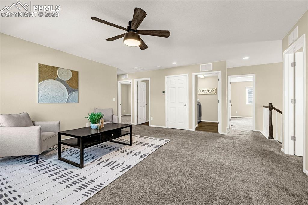 Image 9 of 42: Carpeted loft area with ceiling fan and recessed lighting
