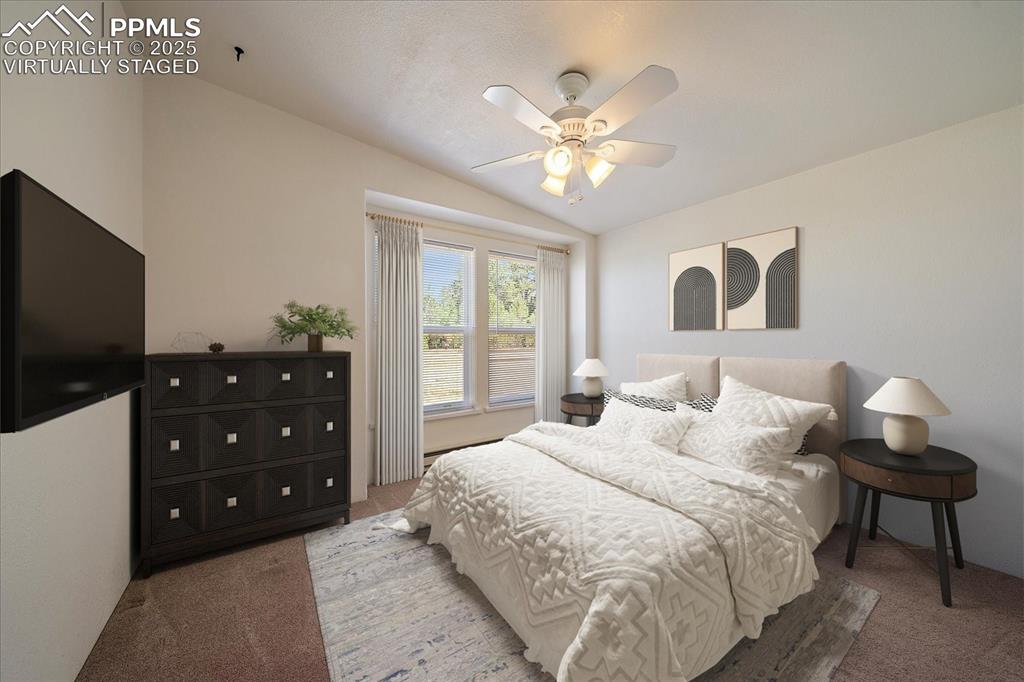 Image 20 of 50: virtually staged bedroom featuring lofted ceiling and a ceiling fan