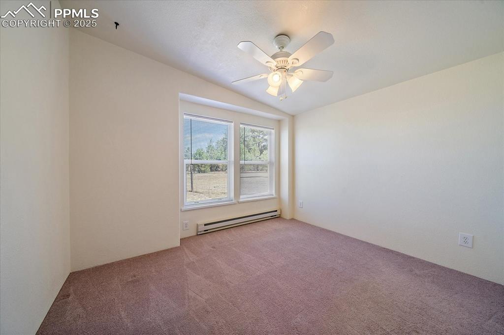 Image 21 of 50: Unfurnished room featuring lofted ceiling, a carpet, and ceiling fan