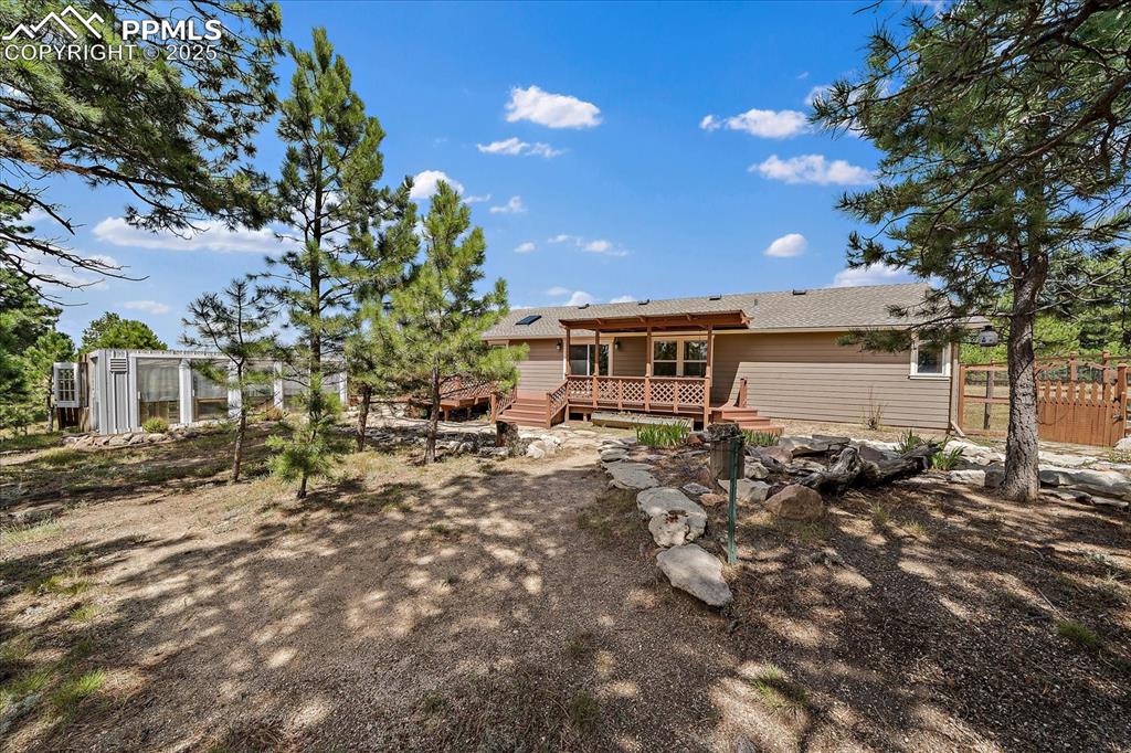 Image 34 of 50: Rear view of property with a wooden deck and roof with shingles