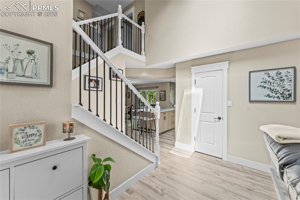 Image 18 of 44: Entrance foyer featuring light wood finished floors, stairs, and a high cei