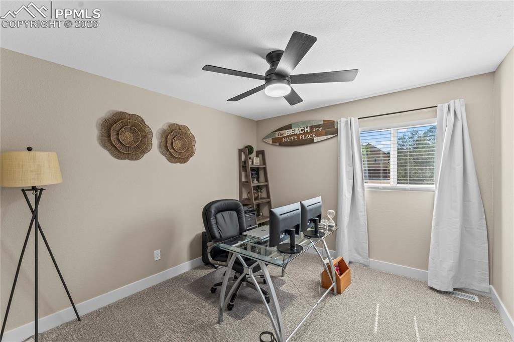 Image 32 of 44: Carpeted office space with baseboards and ceiling fan