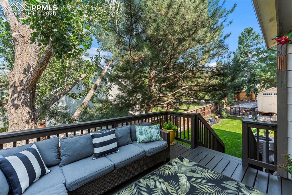 Image 36 of 44: Deck with an outdoor hangout area and a yard