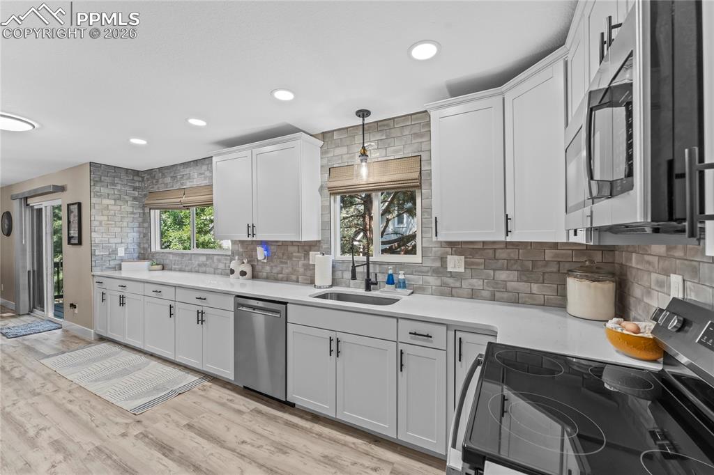 Image 4 of 44: Kitchen featuring stainless steel appliances, tasteful backsplash, light co