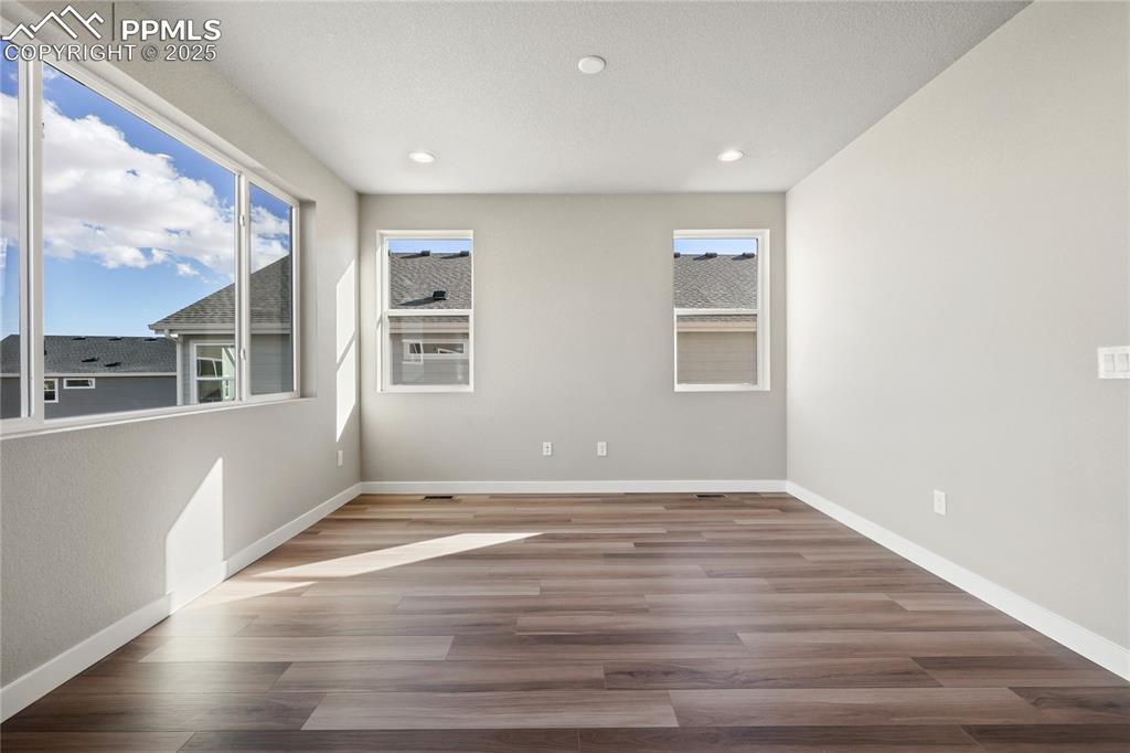 Image 19 of 38: Empty room with wood finished floors and recessed lighting