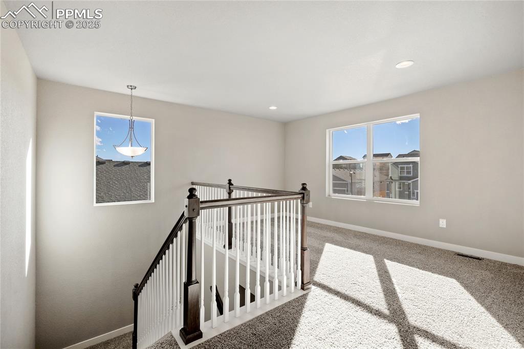 Image 21 of 38: Hall with an upstairs landing, carpet, and recessed lighting