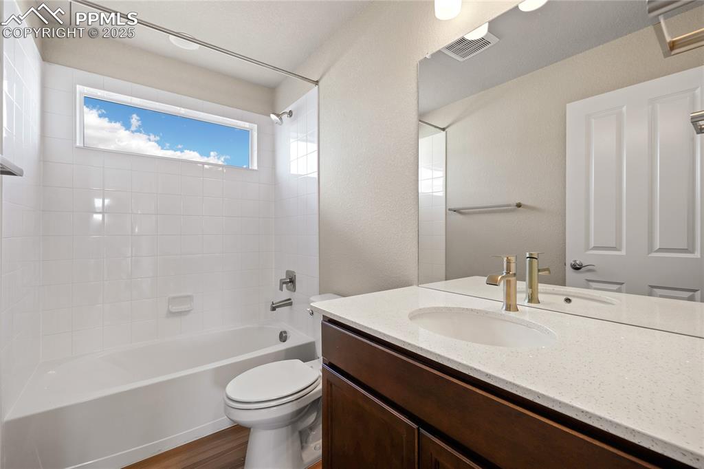 Image 27 of 38: Bathroom featuring shower / tub combination, vanity, wood finished floors,